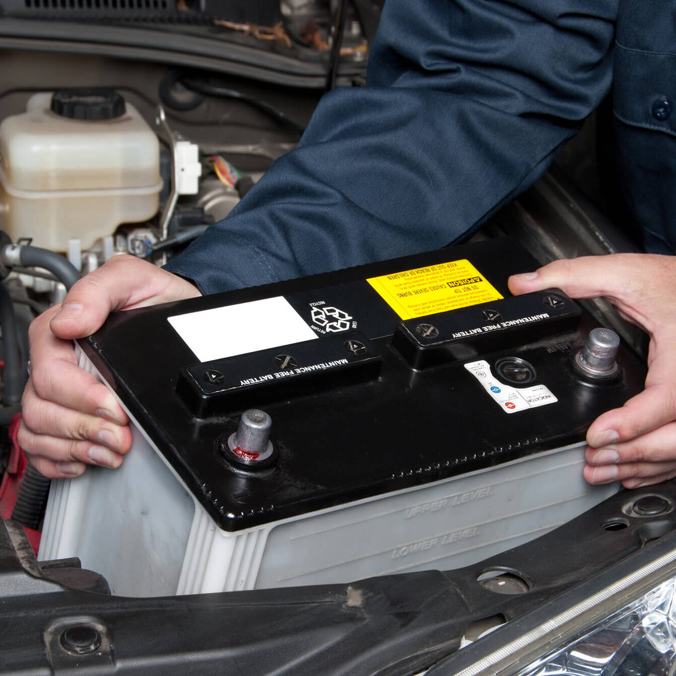 auto-mechanic-replacing-car-battery-NREDMBX (1)